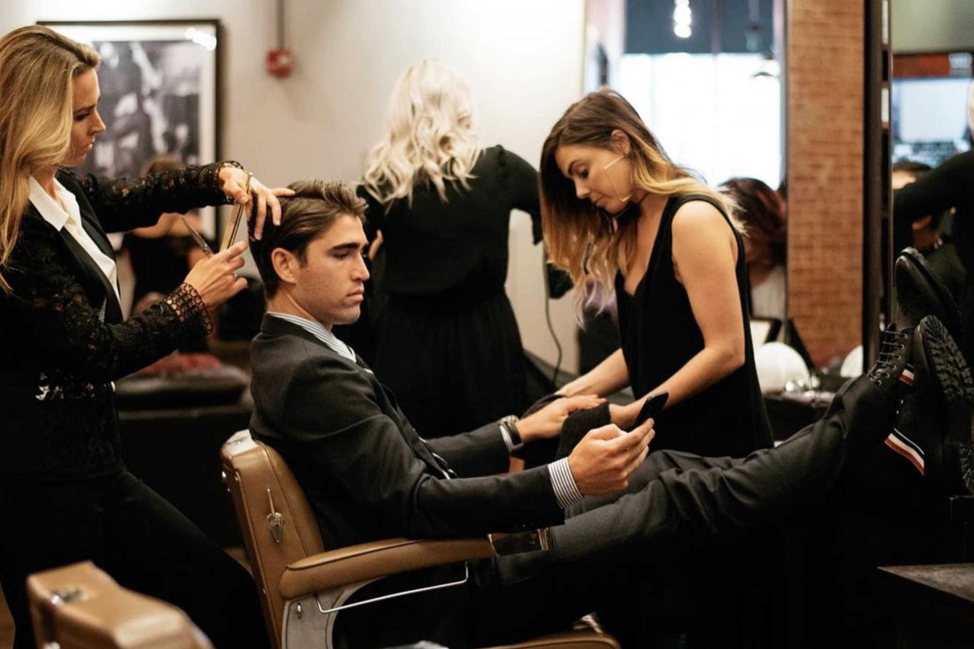 Emerson Joseph client getting standard haircut and hand detail service from two stylists